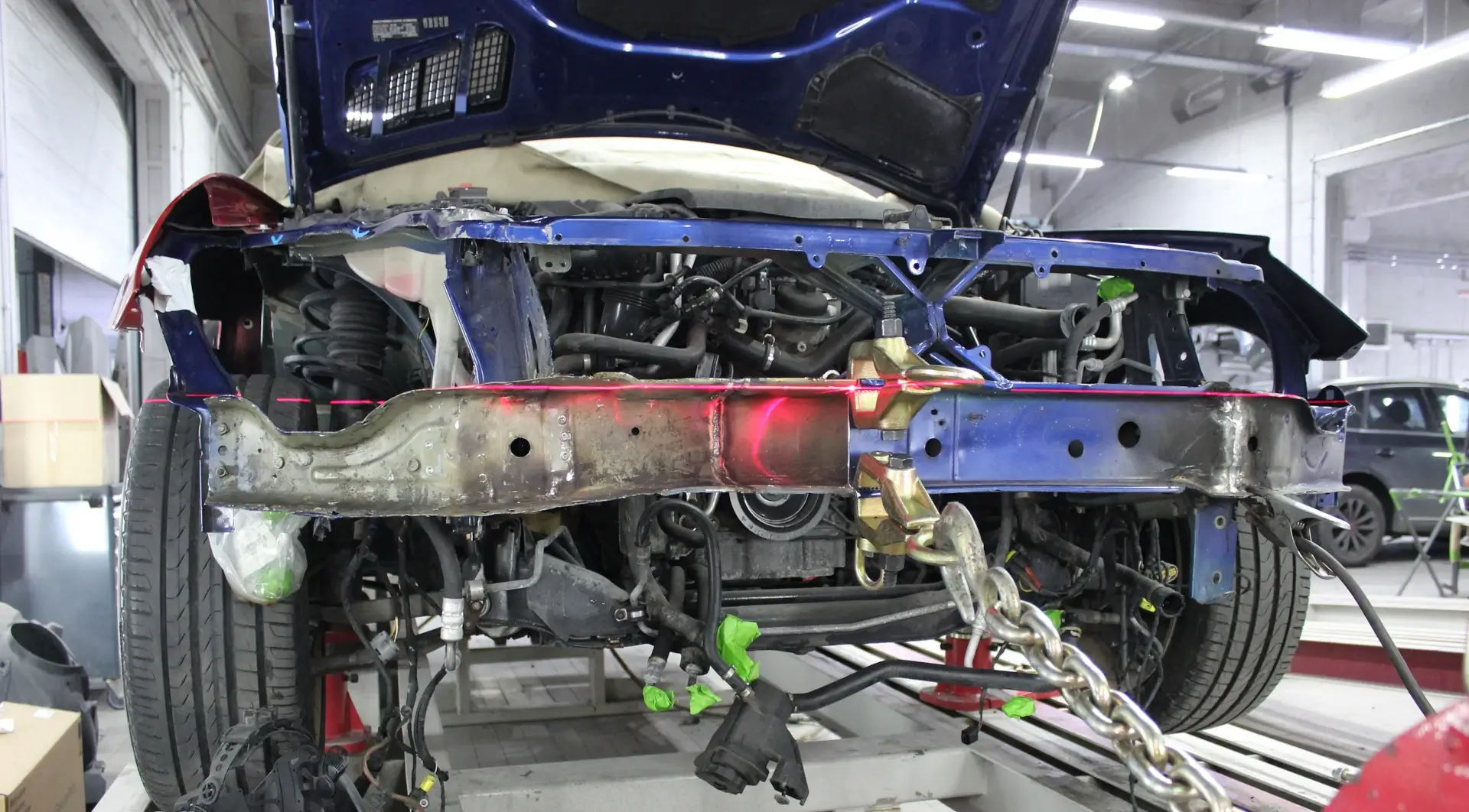 Vehicle frame being straightened with measuring system during collision repair