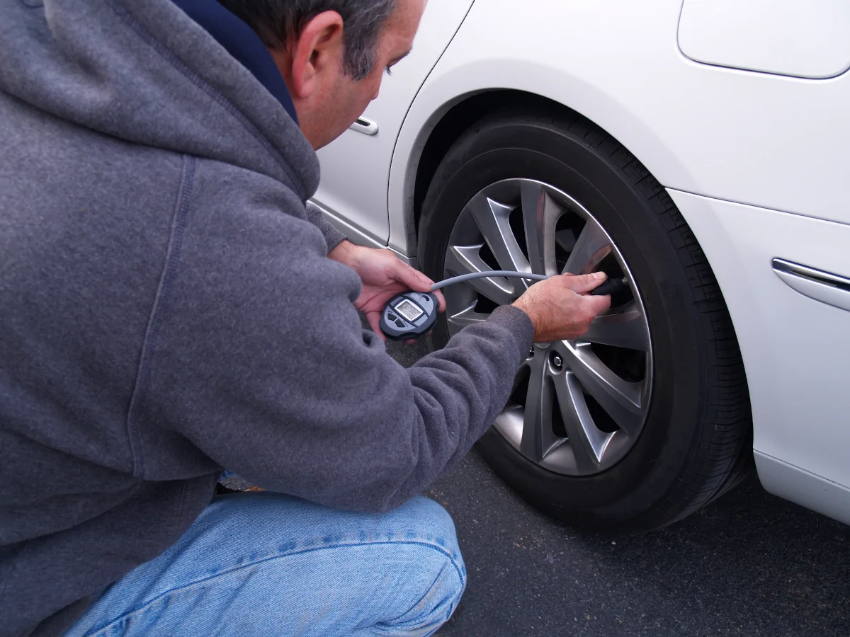 Checking tire pressure before winter driving in Austin