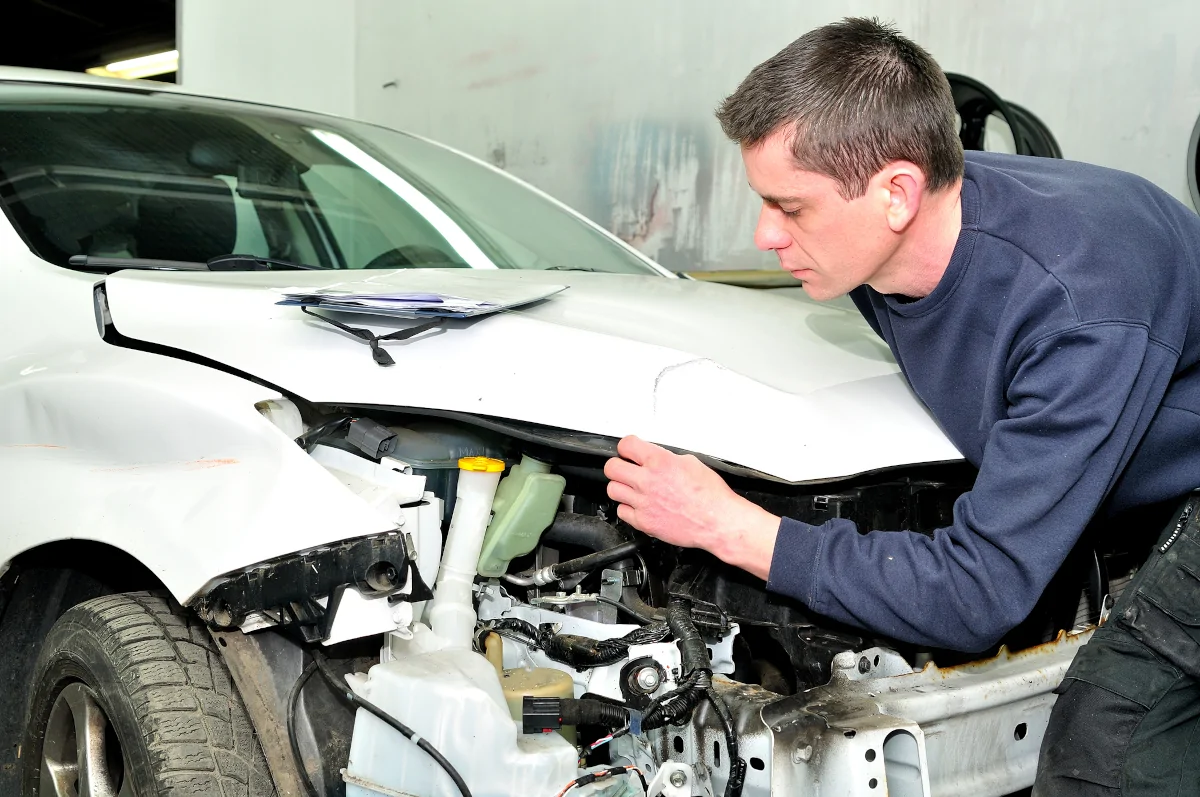 Auto Body Technician inspecting vehicle damage after an accident